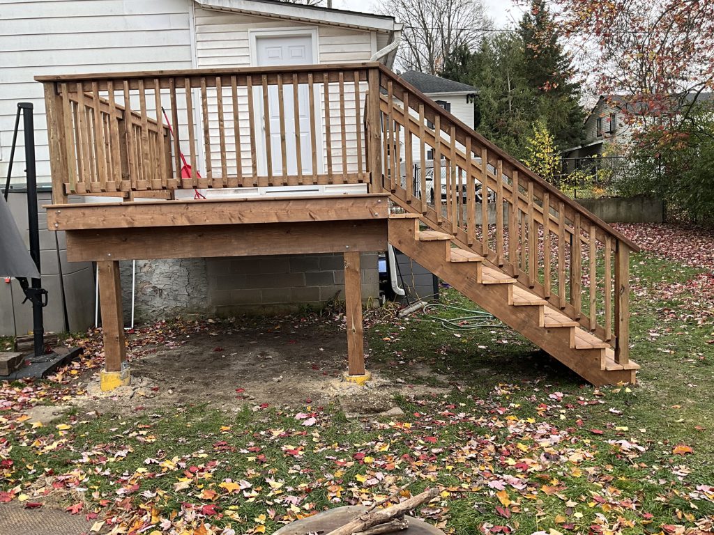 Raised deck with stairs and wood railing