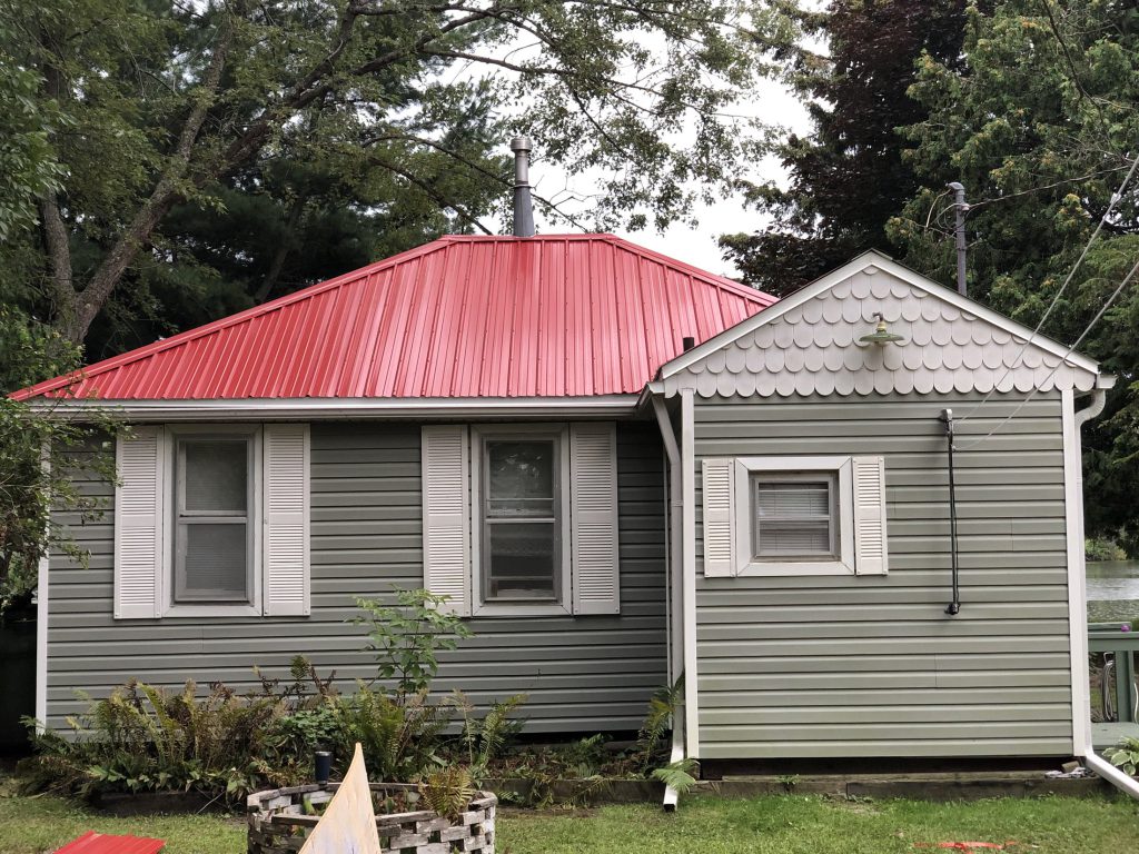 Cottage with newly repaired red barn-steel roof